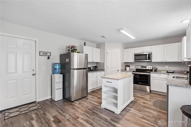 805 Marshall Dr, Xenia, OH 45385 - kitchen with stainless steel appliances, backsplash, white cabinets, wood finished floors, and open shelves