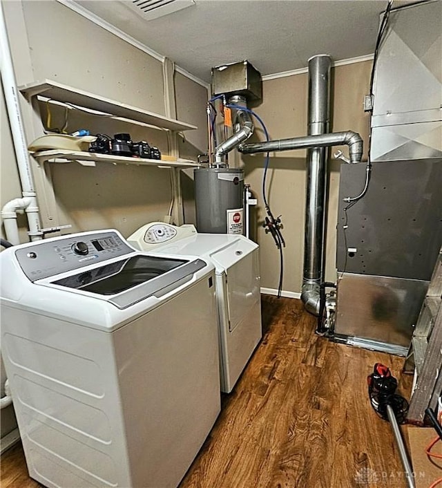 2224 Vale Dr, Kettering, OH 45420 - laundry room with electric water heater, washing machine and dryer, dark wood-style flooring, ornamental molding, and heating unit