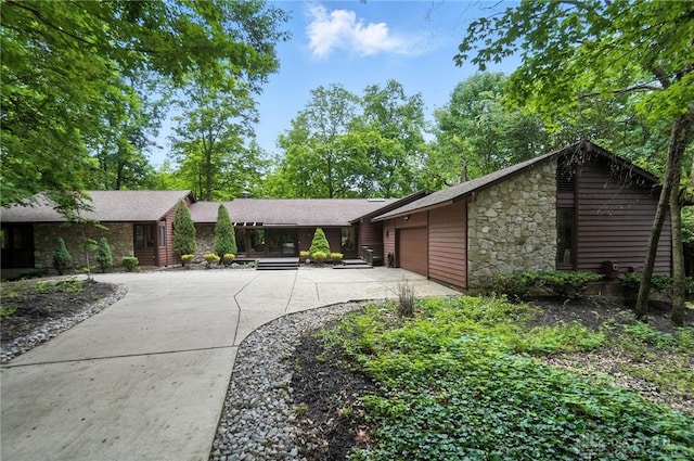 1917 Antrim Ct, Middletown, OH 45042 - view of front of house with stone siding, driveway, a garage, and roof with shingles