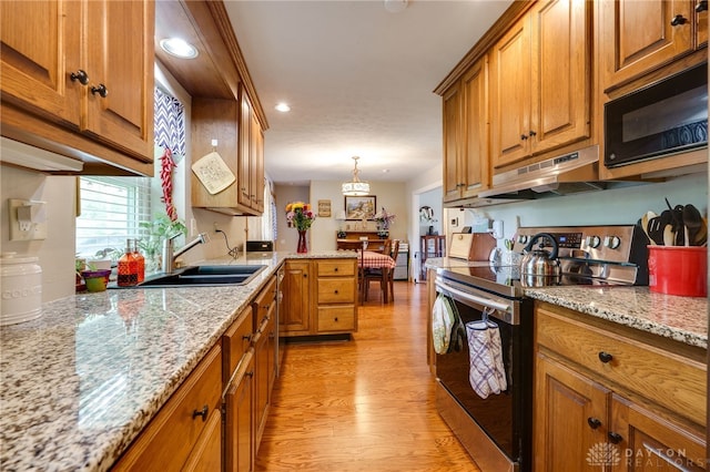 4930 Wildoak Ct, Dayton, OH 45424 - kitchen with electric stove, brown cabinetry, black microwave, light wood-type flooring, and under cabinet range hood