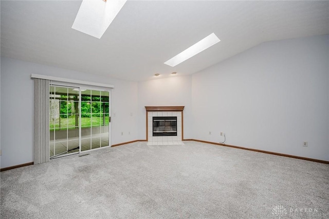 995 Wren Ct, Monroe, OH 45050 - unfurnished living room featuring a skylight, vaulted ceiling, carpet floors, and a tiled fireplace