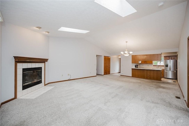 995 Wren Ct, Monroe, OH 45050 - unfurnished living room featuring a skylight, a chandelier, lofted ceiling, a fireplace, and light carpet