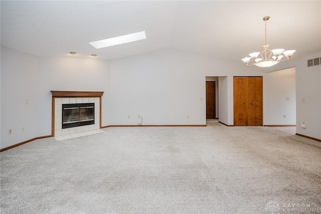995 Wren Ct, Monroe, OH 45050 - unfurnished living room with lofted ceiling, a chandelier, light colored carpet, a fireplace, and a skylight
