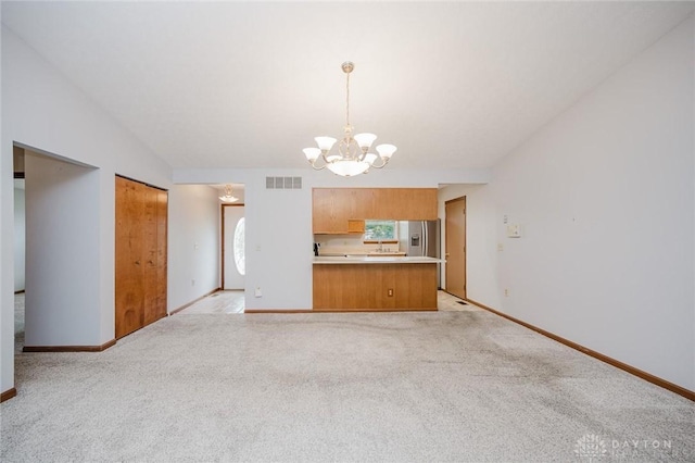 995 Wren Ct, Monroe, OH 45050 - kitchen featuring a chandelier, brown cabinets, light countertops, stainless steel fridge with ice dispenser, and healthy amount of natural light