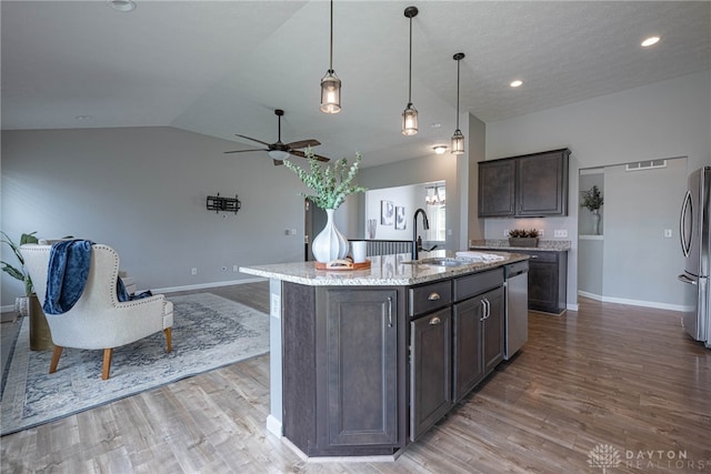 1693 Sunset Canyon Ct, Fairborn, OH 45324 - kitchen with ceiling fan, dark brown cabinets, appliances with stainless steel finishes, vaulted ceiling, and light wood-style floors