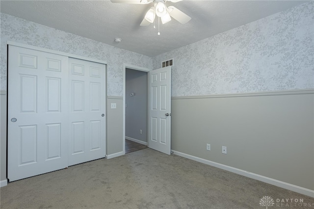 1693 Sunset Canyon Ct, Fairborn, OH 45324 - unfurnished bedroom with wallpapered walls, carpet floors, a ceiling fan, a textured ceiling, and a closet