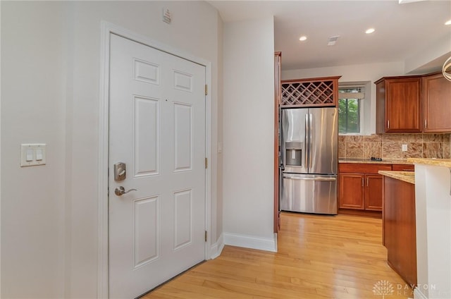 964 Auburnview Dr Unit 3E, Cincinnati, OH 45206 - kitchen with stainless steel refrigerator with ice dispenser, light wood-style floors, light countertops, brown cabinetry, and backsplash