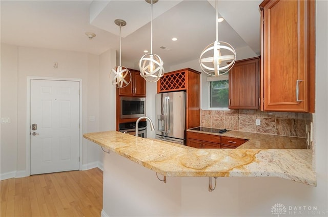 964 Auburnview Dr Unit 3E, Cincinnati, OH 45206 - kitchen featuring appliances with stainless steel finishes, light wood-style floors, backsplash, brown cabinetry, and a peninsula