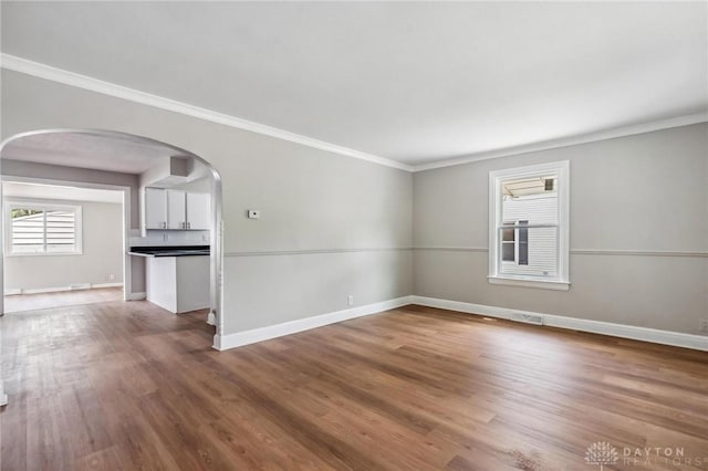 610 N Spring St, Wilmington, OH 45177 - empty room featuring arched walkways, crown molding, and wood finished floors