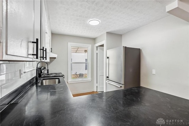 610 N Spring St, Wilmington, OH 45177 - kitchen with freestanding refrigerator, a textured ceiling, and dark countertops