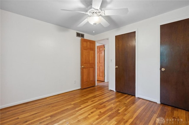 1620 Ambridge Rd, Dayton, OH 45459 - unfurnished bedroom with light wood finished floors, ceiling fan, and multiple closets