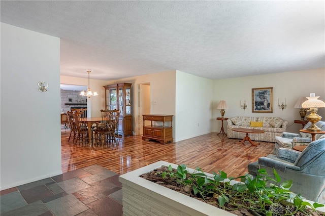 9131 Shawhan Dr, Centerville, OH 45458 - living room featuring a chandelier, wood finished floors, and a textured ceiling