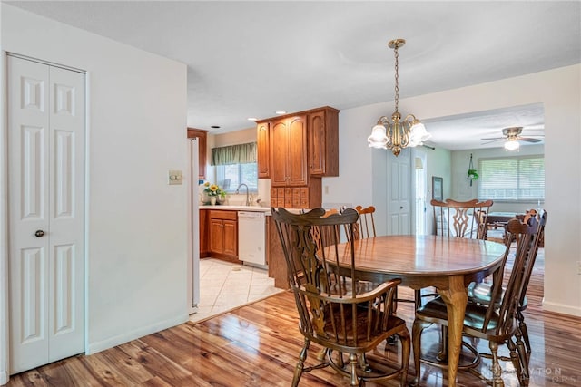9131 Shawhan Dr, Centerville, OH 45458 - dining room with light wood finished floors, a chandelier, and a ceiling fan