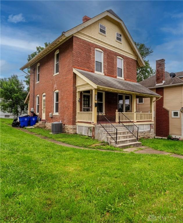 246 N D St, Hamilton, OH 45013 - traditional style home featuring covered porch, a front yard, brick siding, and a chimney
