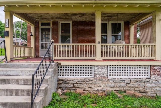 246 N D St, Hamilton, OH 45013 - doorway to property featuring covered porch and brick siding