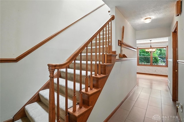 356 Saint James Pl, Springboro, OH 45066 - staircase with a textured ceiling, a chandelier, and tile patterned floors