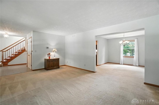 356 Saint James Pl, Springboro, OH 45066 - spare room featuring carpet floors, a chandelier, stairway, and a textured ceiling