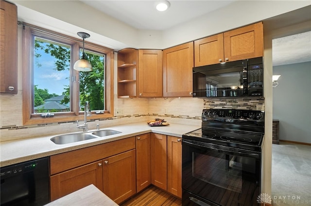 356 Saint James Pl, Springboro, OH 45066 - kitchen with black appliances, brown cabinetry, light countertops, pendant lighting, and decorative backsplash
