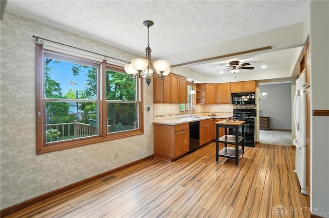 356 Saint James Pl, Springboro, OH 45066 - kitchen with black appliances, light wood finished floors, a chandelier, light countertops, and brown cabinets