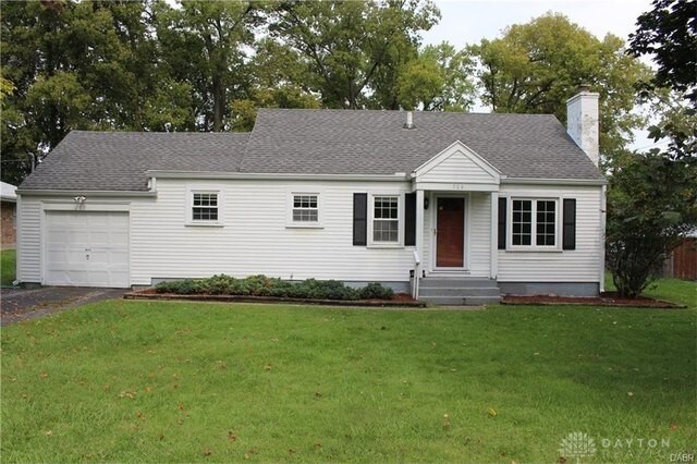 508 Shiloh Dr, Harrison Twp, OH 45415 - view of front of home featuring an attached garage, a chimney, driveway, a front lawn, and roof with shingles