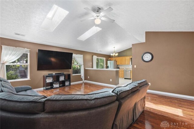 5545 Stone Path Dr, Middletown, OH 45042 - living room featuring a skylight, wood finished floors, a chandelier, ceiling fan, and vaulted ceiling