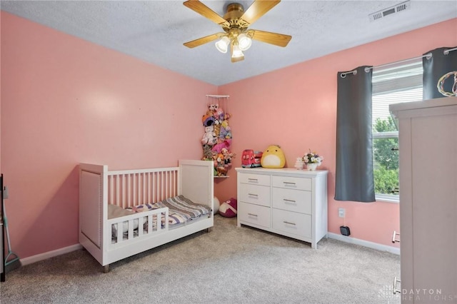 5545 Stone Path Dr, Middletown, OH 45042 - carpeted bedroom with a nursery area, ceiling fan, and a textured ceiling