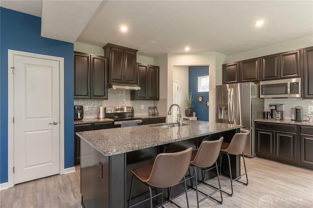 2225 Cold Stream Dr, Clearcreek Twp, OH 45458 - kitchen with stainless steel appliances, a kitchen breakfast bar, backsplash, light stone countertops, and recessed lighting