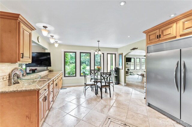 255 Belle Watlin Ct, Dayton, OH 45434 - kitchen featuring built in fridge, light stone counters, arched walkways, tasteful backsplash, and recessed lighting