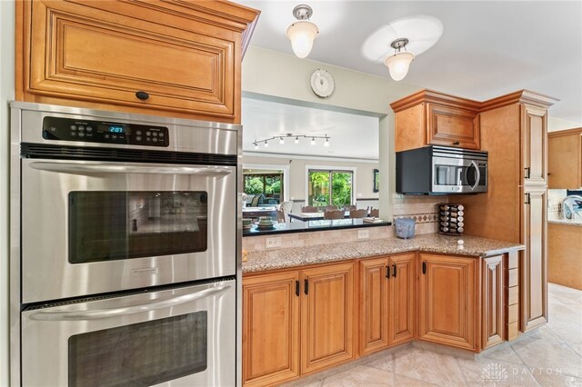 255 Belle Watlin Ct, Dayton, OH 45434 - kitchen featuring stainless steel appliances, tasteful backsplash, light stone countertops, and brown cabinetry