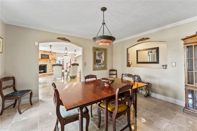 255 Belle Watlin Ct, Dayton, OH 45434 - dining area featuring crown molding, light tile patterned floors, arched walkways, and a fireplace