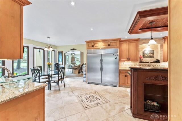 255 Belle Watlin Ct, Dayton, OH 45434 - kitchen with stainless steel built in refrigerator, arched walkways, backsplash, decorative light fixtures, and light stone counters