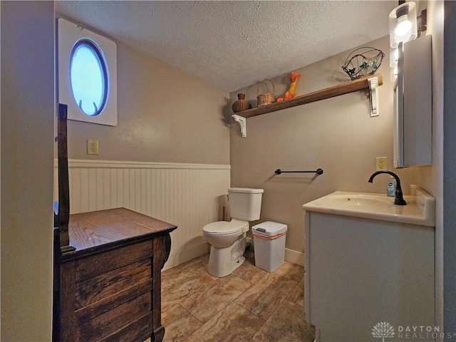 3054 Carpenter Rd, Jefferson Twp, OH 45335 - bathroom featuring a textured ceiling, vanity, and a wainscoted wall