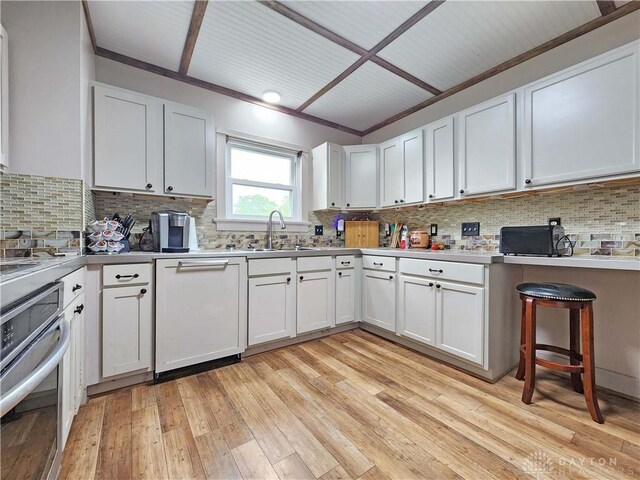 3054 Carpenter Rd, Jefferson Twp, OH 45335 - kitchen featuring dishwasher, oven, tasteful backsplash, light wood-style floors, and white cabinets