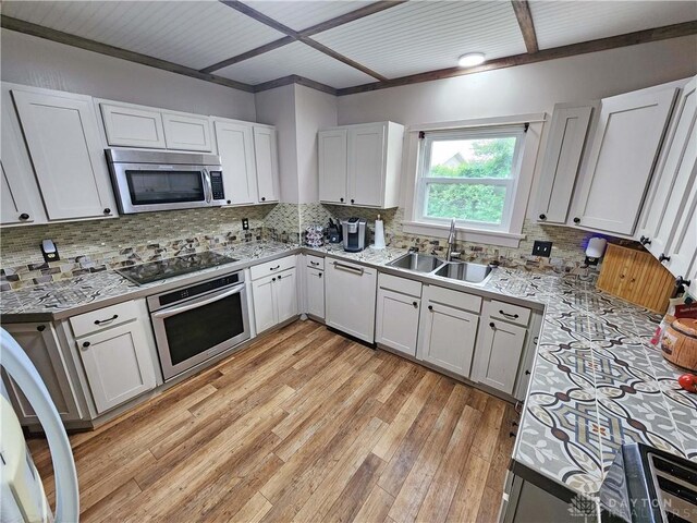 3054 Carpenter Rd, Jefferson Twp, OH 45335 - kitchen with appliances with stainless steel finishes, light countertops, light wood-style flooring, backsplash, and white cabinets