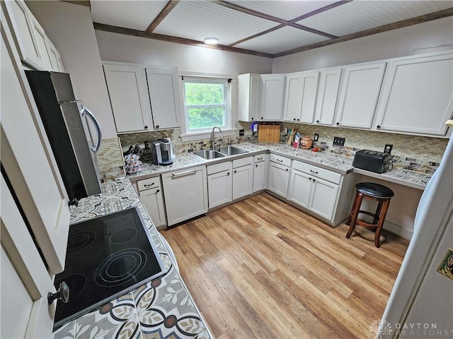 3054 Carpenter Rd, Jefferson Twp, OH 45335 - kitchen featuring white dishwasher, black electric stovetop, decorative backsplash, light wood finished floors, and white cabinetry
