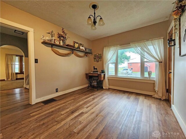 3054 Carpenter Rd, Jefferson Twp, OH 45335 - unfurnished dining area with arched walkways, hardwood / wood-style flooring, healthy amount of natural light, and a textured ceiling