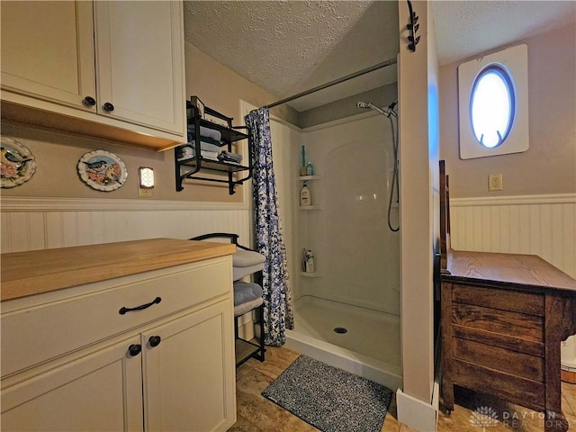 3054 Carpenter Rd, Jefferson Twp, OH 45335 - bathroom with a textured ceiling, a wainscoted wall, and a shower stall