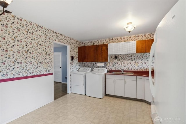 242 Poe Ln, Xenia, OH 45385 - laundry area featuring cabinet space, wallpapered walls, independent washer and dryer, and light flooring