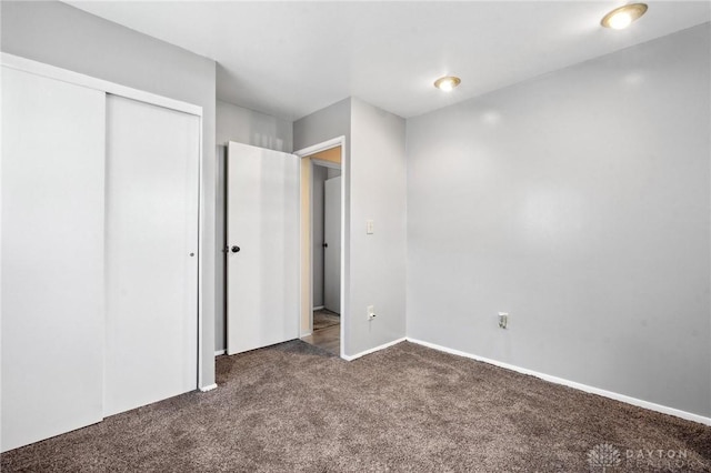 242 Poe Ln, Xenia, OH 45385 - unfurnished bedroom featuring dark colored carpet and a closet