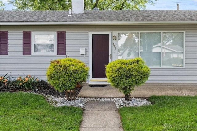 242 Poe Ln, Xenia, OH 45385 - property entrance featuring a chimney, a lawn, and roof with shingles