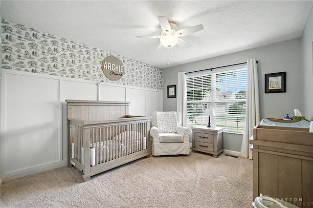 3109 Running Deer Trl, Franklin Twp, OH 45005 - bedroom with a crib, carpet flooring, wallpapered walls, a wainscoted wall, and a ceiling fan