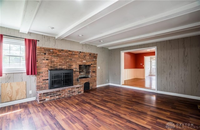 187 Cheltenham Dr, Washington Twp, OH 45459 - unfurnished living room featuring wood finished floors, plenty of natural light, beam ceiling, a fireplace, and wooden walls
