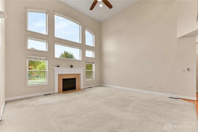 9764 Olde Georgetown Way, Dayton, OH 45458 - unfurnished living room featuring a towering ceiling, ceiling fan, a fireplace, and light carpet