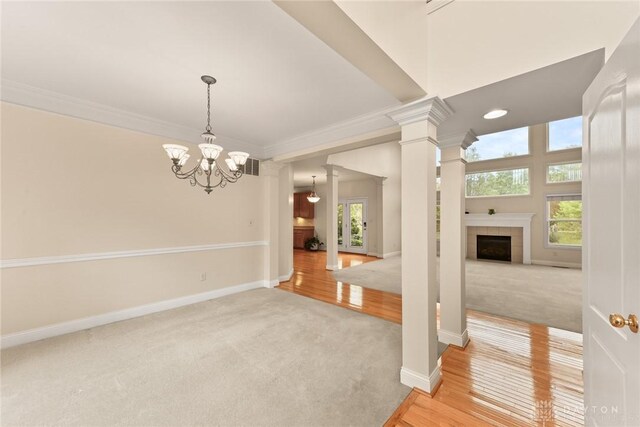 9764 Olde Georgetown Way, Dayton, OH 45458 - empty room with light carpet, ornamental molding, a fireplace, a chandelier, and ornate columns
