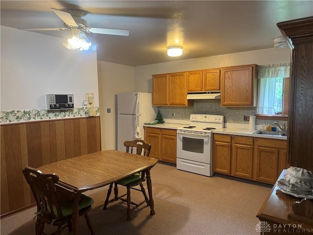 435 Nies Ave, Englewood, OH 45322 - kitchen with white appliances, under cabinet range hood, brown cabinetry, a ceiling fan, and light countertops