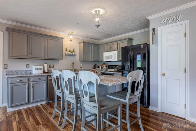 30 Salem Dr, Springboro, OH 45066 - kitchen featuring white microwave, range with electric stovetop, gray cabinets, freestanding refrigerator, and dark wood-style floors