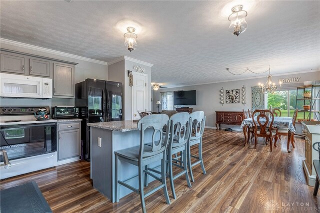 30 Salem Dr, Springboro, OH 45066 - kitchen featuring white appliances, a kitchen bar, gray cabinets, dark wood-type flooring, and ornamental molding