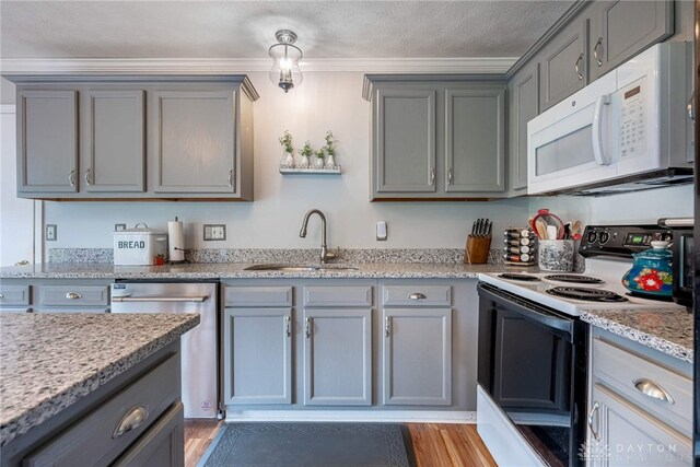 30 Salem Dr, Springboro, OH 45066 - kitchen with white microwave, electric range, dishwasher, gray cabinets, and light wood-style flooring