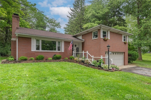 3105 Shadow Hill Rd, Middletown, OH 45042 - tri-level home featuring a chimney, an attached garage, brick siding, asphalt driveway, and a front yard