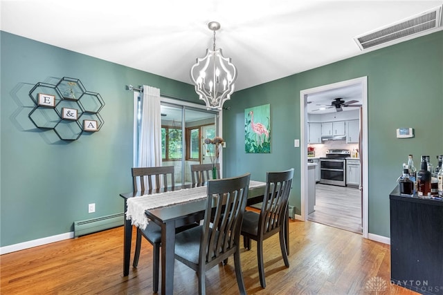 3105 Shadow Hill Rd, Middletown, OH 45042 - dining area featuring a baseboard heating unit, a chandelier, and light wood finished floors